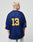 A person with short, bleached blonde hair wears the oversize LFDY Mesh Jersey by LIVE FAST DIE YOUNG. The loose-fit blue polyester jersey features a V-neck and yellow number 13 on the back and sleeves. The person faces away from a plain background.