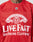 A person wears the LFDY Hockey Jersey by LIVE FAST DIE YOUNG—a red, polyester oversize-fit jersey with white LIVE FAST DIE YOUNG CLOTHING, smaller WITH US OR AGAINST US and LIVING FASTER text, plus an NHL-style patch near the collar.