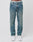 A person wears LIVE FAST DIE YOUNG Regular Denim jeans in light blue, featuring a regular fit and tapered leg made from recycelte Baumwolle, paired with white sneakers. The photo shows the jeans from the waist down against a plain white background.