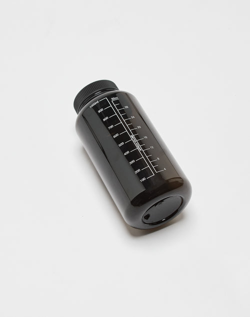 The LIVE FAST DIE YOUNG Live Fast Performance Gym Bottle (LF2501-17113) is a black 100% Tritan, BPA-free bottle with a black screw cap and milliliter markings from 100ml to 1000ml, lying on its side on a white surface.