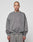 A person with a shaved head wears the LIVE FAST DIE YOUNG Basic Chest Sweater in an oversized, faded gray fit, paired with matching sweatpants and a subtle front print, standing facing forward against a plain light gray background.