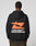 A person in a black LFDY Hardwear Hooded by LIVE FAST DIE YOUNG, made from Baumwolle with an orange abstract graphic and LIVE FAST HARDWEAR on the back, stands against a plain light gray background.