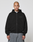 A person with a shaved head wears the LIVE FAST DIE YOUNG Basic 510 Hooded Zip in black (Oversize Fit) and gray baggy jeans, standing forward against a plain white background.
