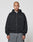 A person with a shaved head wears the LIVE FAST DIE YOUNG Basic 510 Hooded Zip in Oversize Fit and gray jeans, standing facing forward against a plain light gray background.