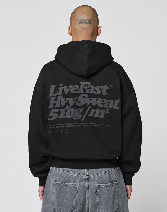 A person with a tattoo on the back of their head wears a LIVE FAST DIE YOUNG Basic 510 Hooded Zip in Oversize Fit with large gray front and back print, paired with gray jeans, facing away from the camera. | model