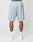 A person faces away wearing LIVE FAST DIE YOUNG LFDY Loyal Shorts in light blue mesh polyester with an elastic waistband and a small right back pocket, paired with white crew socks and sneakers, against a plain white background.
