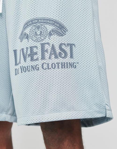 The LFDY Loyal Shorts by LIVE FAST DIE YOUNG are light blue polyester mesh athletic shorts with an oversized fit and elastic waistband. LIVE FAST, DIE YOUNG CLOTHING, an eye graphic, and WITH US OR AGAINST US appear on the left leg.