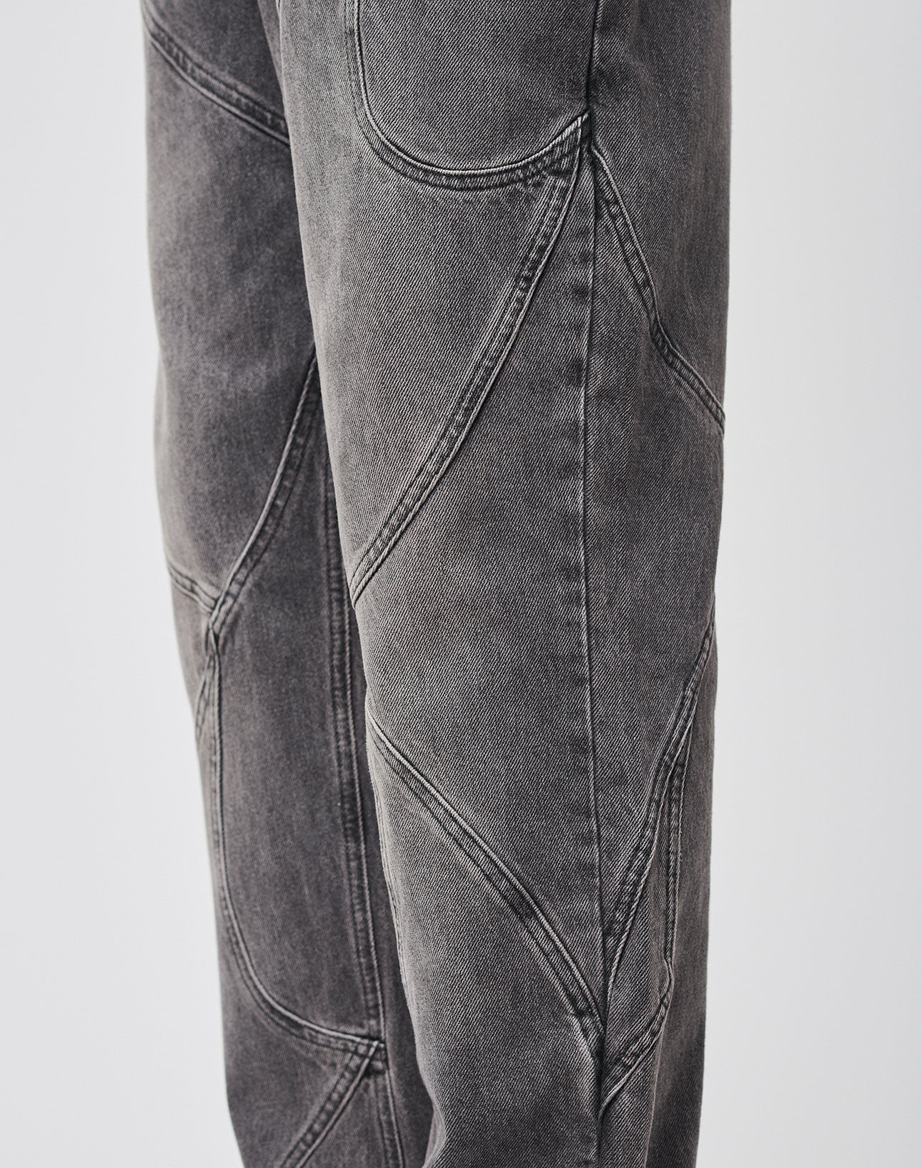 Close-up of LIVE FAST DIE YOUNG’s Tribal Wide Denim: gray 100% Baumwolle pants with curved seams and tribal paneling for a geometric patchwork look. Baggy fit brings relaxed edge to this unique design.