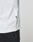 Close-up of a person wearing the LIVE FAST DIE YOUNG Basic Live Fast Graffiti Tee (100% Baumwolle, white, small black side tag) with black pants, standing against a plain light gray background.