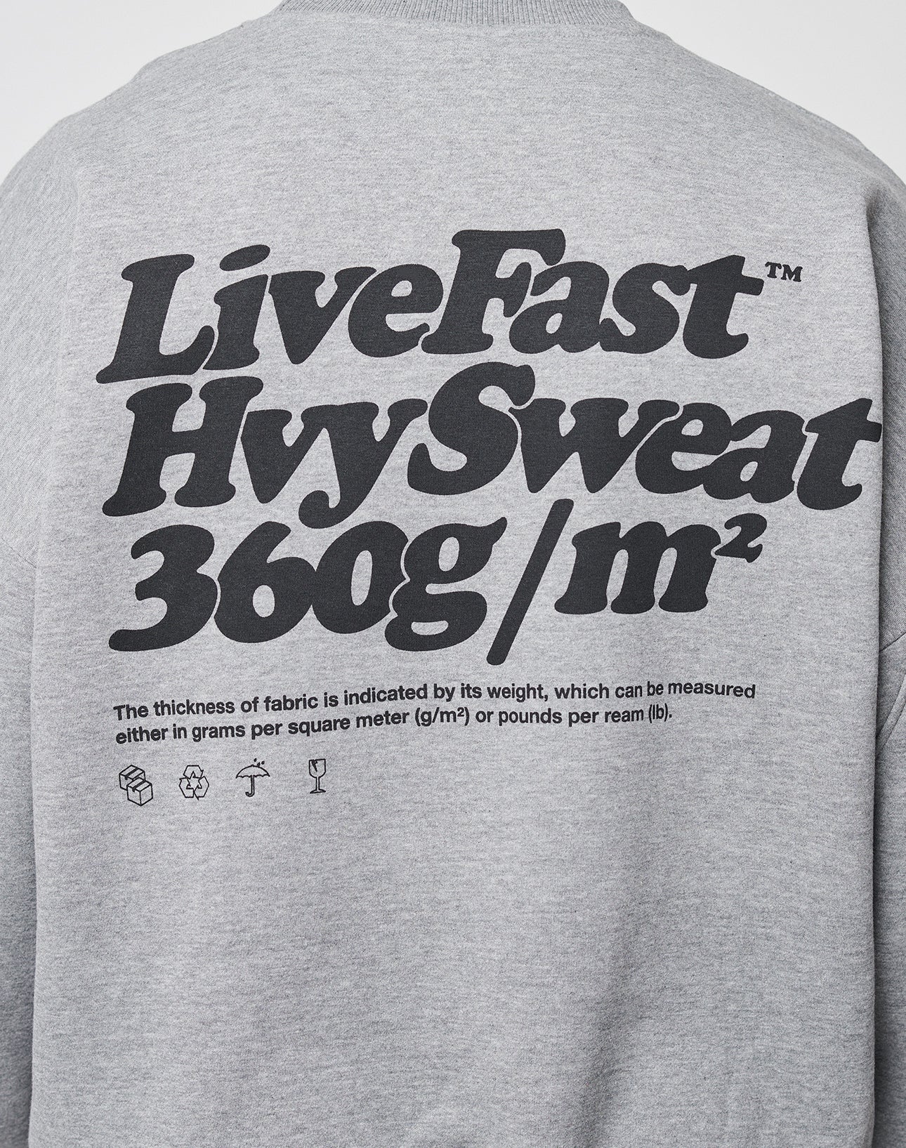 The Basic 360 Sweater by LIVE FAST DIE YOUNG is a gray oversized sweatshirt with bold black text on the back and stylish front/back prints. It features small print explaining fabric thickness in g/m² or lbs/ream.
