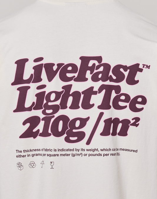 The Basic 210 Tee by LIVE FAST DIE YOUNG is a white oversized T-shirt with bold purple "Live Fast" text, fabric weight info (210g/m²), small icons, and features prints on both front and back. Made from 100% Baumwolle for standout style.