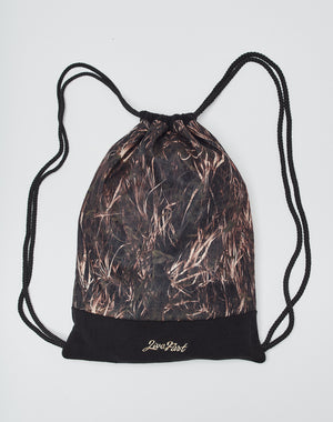 The Live Fast Gymbag by LIVE FAST DIE YOUNG is a polyester drawstring backpack with black cords, a brown and black camo pattern, and Live First in gold on a solid black bottom, shown on a plain white background.
