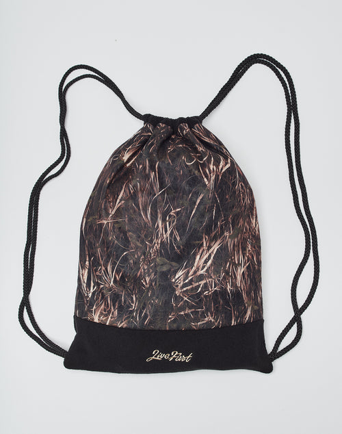 The Live Fast Gymbag by LIVE FAST DIE YOUNG is a polyester drawstring backpack with black cords, a brown and black camo pattern, and Live First in gold on a solid black bottom, shown on a plain white background.