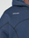 Close-up of the LFDY Active Fleece Hooded Zip by LIVE FAST DIE YOUNG, featuring an oversize navy blue fit in cotton with black stitching and a white LIVE FAST logo on the chest. Part of the wearer's neck and chin are visible.