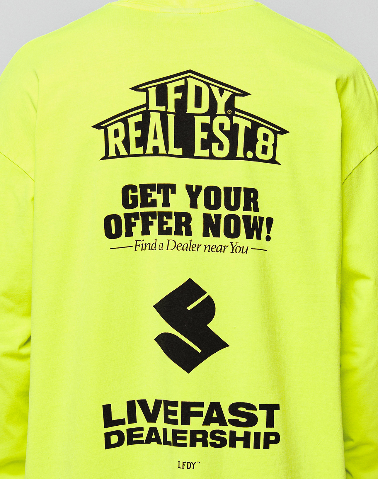 Back of the bright yellow LFDY Real Est.8 Longsleeve by LIVE FAST DIE YOUNG in Oversize Fit, with bold black text, stylized logo, and LIVEFAST DEALERSHIP print. Made from 100% Baumwolle, features striking Front- und Backprint.