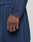 A close-up of a hand and forearm wearing the LIVE FAST DIE YOUNG LFDY Active Fleece Hooded Zip in navy blue, featuring an oversize fit and black stitching. Matching pants are shown against a neutral, blurred background.