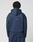 A person with short, twisted hair is seen from behind wearing the LFDY Active Fleece Hooded Zip by LIVE FAST DIE YOUNG—a navy blue oversize sweatshirt with black curved seams and a small white logo print at the center back, made of Baumwolle.