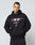 A person with short dark hair and neck and hand tattoos wears the LIVE FAST DIE YOUNG LFDY Triple Racing Hooded, an oversize black Baumwolle sweatshirt with multilogo pink and white graphic text and numbers on the front, standing against a plain light background.