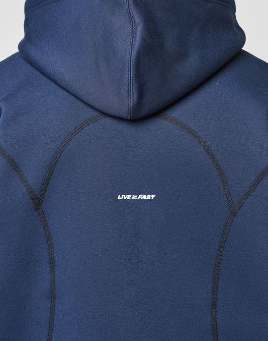 A close-up of the back of the LFDY Active Fleece Hooded Zip by LIVE FAST DIE YOUNG, an oversized navy hoodie made from 100% cotton with black stitched seams and a white LIVE 2 FAST logo print at the center.
