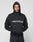 A person wears the Basic +49 Hooded by LIVE FAST DIE YOUNG, an oversized black hoodie with +49LiveFast front print, hands in pockets and hood up, standing against a plain light background. Crafted from a comfy cotton-polyester blend.