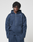 A young man with short, textured dreadlocks wears the navy LFDY Active Fleece Hooded Zip and matching pants by LIVE FAST DIE YOUNG, featuring a subtle logo print and crafted from soft Baumwolle, standing against a plain light gray background.
