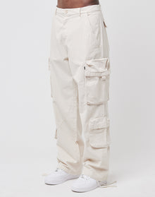 A person wears the LIVE FAST DIE YOUNG Wide Summer Cargo—loose, off-white 100% Baumwolle Ripstop pants with multiple Cargotaschen—paired with white sneakers, standing against a plain white background.