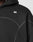 Close-up of the LFDY Active Fleece Hooded Zip by LIVE FAST DIE YOUNG in black, featuring an oversized fit, visible stitching, and a small white logo on the chest. The hood is up, showing part of the wearer’s shoulder, neck, and jawline.