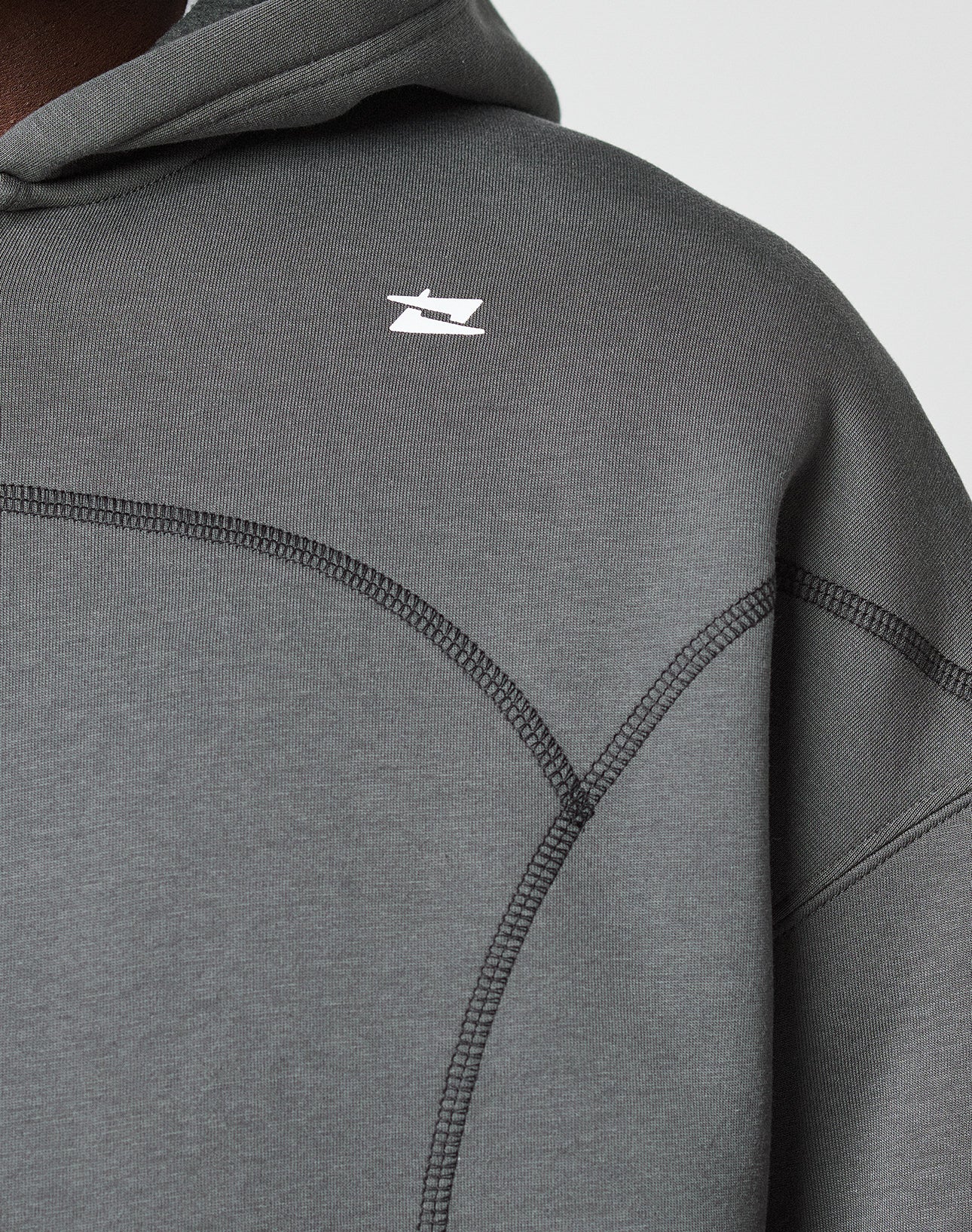 Close-up of the LIVE FAST DIE YOUNG LFDY Active Fleece Hooded Zip in dark gray, featuring black seam details and a small white logo on the chest. Image shows the shoulder and upper chest area of this 100% Baumwolle piece.