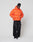 A person stands against a white background wearing the LIVE FAST DIE YOUNG Live Fast Puffer Jacket in bright orange with reflective print, paired with a black beanie, loose black jeans, and white sneakers.