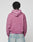 A person with short, twisted hair is seen from behind wearing the LIVE FAST DIE YOUNG Live Fast Rivet Hooded Zip in faded mauve (Oversize Fit), paired with light blue jeans, standing against a plain light gray background.
