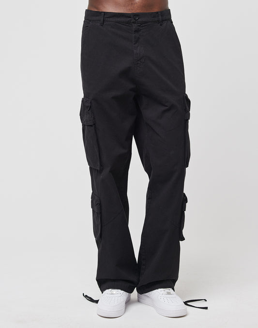 A person wears LIVE FAST DIE YOUNG Wide Summer Cargo pants with multiple cargo pockets and white sneakers, standing against a plain white background. The image is cropped at the waist, showing only the lower body.