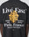The LFDY Paris Tee by LIVE FAST DIE YOUNG is a black oversized 100% cotton T-shirt with bold front and back prints. The back features Live Fast, Le monde est à nous, a gold emblem, and Paris, France plus address in unique fonts.