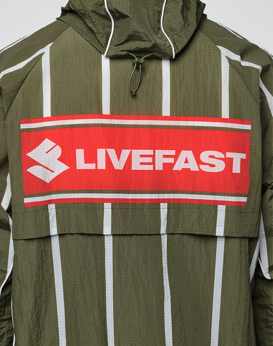 The LFDY Nylon Trackjacket by LIVE FAST DIE YOUNG is olive green with white vertical stripes, a hood with elastic drawcord, bold front and back prints including a large red patch with “LIVEFAST,” and features an oversize fit for a statement look.