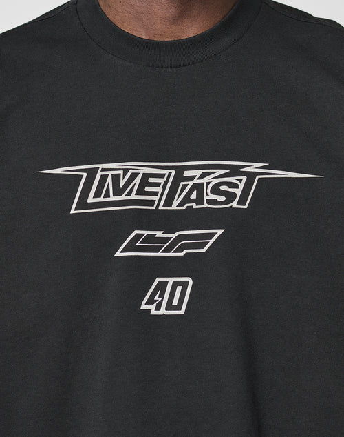 A close-up of the LFDY Triple Racing Tee by LIVE FAST DIE YOUNG—a black, 100% Baumwolle oversized shirt with multilogo front print, bold white LIVE FAST lettering, LF symbols, and the number 40 for ultimate comfort.