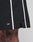 Close-up of a person wearing Basic Cotton Shorts by LIVE FAST DIE YOUNG, featuring a regular fit, black color with white vertical stripes, elastic waistband, front slit, and white LFDY logo print near the above-the-knee hem.