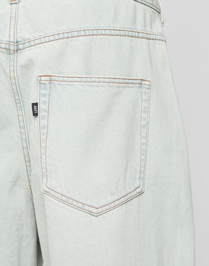 Close-up of the back pocket on LFDY Baggy Denim by LIVE FAST DIE YOUNG, showing a Flag-Label at the side seam, brown stitching, and slightly faded Baumwolle fabric for classic character.