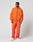 A man stands against a plain background in the LIVE FAST DIE YOUNG Live Fast Trackjacket, a bright orange nylon-elastane zip-up and matching pants with elastic cuffs, paired with white sneakers. He looks to his left with relaxed confidence.