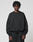 A man wearing the LIVE FAST DIE YOUNG Basic Evidence Sweater, an oversized black cotton-polyester sweatshirt with stylish front and back prints.