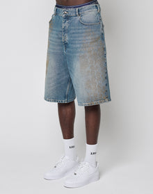 A person wears faded, baggy fit LFDY Tire Tracks Jorts by LIVE FAST DIE YOUNG, knee-length denim shorts, paired with white socks featuring LEDI text and white sneakers. Only the lower body is visible against a plain white background.