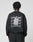A person with short, twisted hair faces away from the camera, wearing the LIVE FAST DIE YOUNG Basic Evidence Sweater—an oversized black Baumwolle Polyester sweatshirt with bold LiveFast front and back prints layered in white graphics.