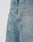 Close-up of the back of LIVE FAST DIE YOUNG LFDY Tire Tracks Jorts, showing baggy light blue denim, two rear pockets, visible stitching, and a small black fabric tag by the right pocket seam.
