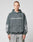 A person wearing the LFDY Window Hooded by LIVE FAST DIE YOUNG, a dark gray oversized hoodie made of 100% Baumwolle with a reflektierender LIVE FAST Frontprint and sleeve graphics, stands against a plain light gray background.