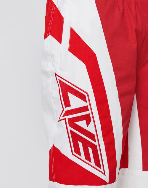 The LFDY Cross Pants by LIVE FAST DIE YOUNG feature red and white bold angular patterns, LIVE lettering on the side, Stick Applikationen, an oversize fit, and sporty fabric shown in a close-up of the left leg.