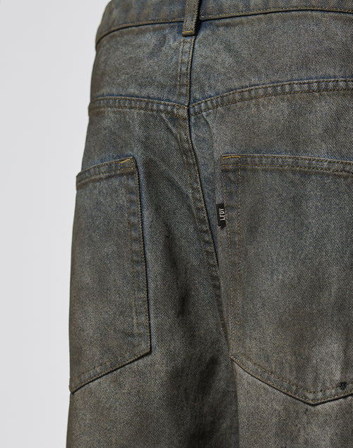 Close-up of the back of LIVE FAST DIE YOUNG’s LFDY Coated Baggy Denim, featuring dark, faded Baumwolle fabric, two large back pockets with contrast stitching, belt loops, and a small black tag on the right pocket.