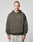A person with short hair wears the LIVE FAST DIE YOUNG Live Fast Plain Hooded in dark olive, oversized fit with LIVE FAST on the chest, made from a soft cotton-polyester blend, paired with light marble pants against a gray background.