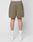 A person faces away, wearing olive green LIVE FAST DIE YOUNG Basic Mesh Shorts with elastic waistband, white socks, and white sneakers. The shorts have a back right pocket and a subtle logo patch. Background is plain white.