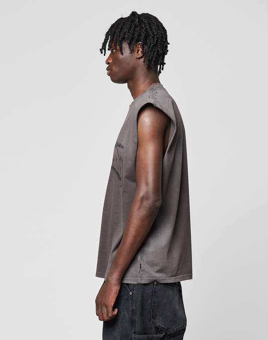 A person with short, twisted hair stands in profile against a plain background, wearing the oversize fit LFDY Flames Muscle Shirt by LIVE FAST DIE YOUNG, made from 100% Baumwolle, paired with dark pants.