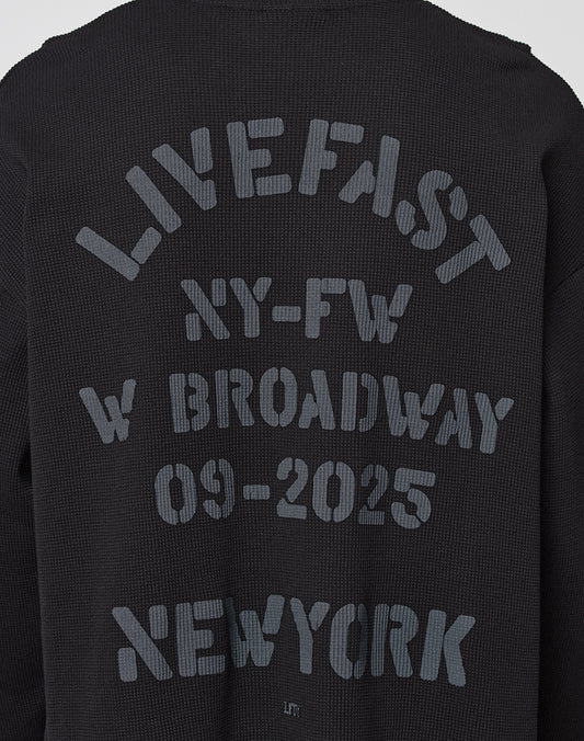 The NY-FW Waffle Longsleeve by LIVE FAST DIE YOUNG features black textured fabric and a bold gray backprint: LIVE FAST NY-FW W BROADWAY 09-2025 NEW YORK, showcased on an oversized fit.