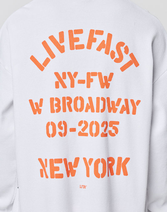 The NY-FW Waffle Longsleeve by LIVE FAST DIE YOUNG is an oversized white 100% cotton top with textured fabric and a striking orange backprint: LIVE FAST NY-FW W BROADWAY 09-2025 NEW YORK LFDY.