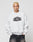 A person with short bleached blond hair wears the LFDY Emblem Sweater by LIVE FAST DIE YOUNG, an Oversize Fit light gray sweatshirt with LIVE FAST in bold black letters, standing against a plain light background.